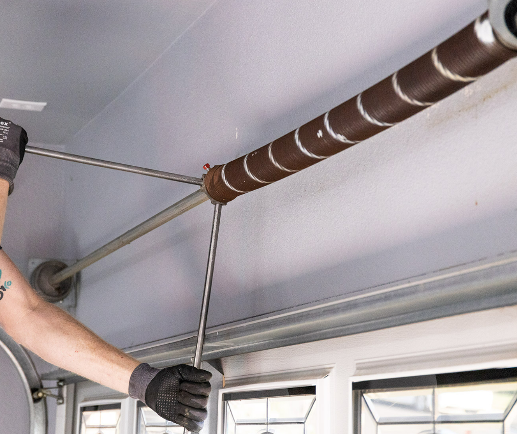 Technician performing garage door spring repair for a residential home in Sun City Center, Florida