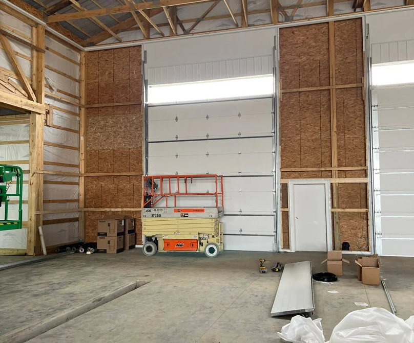 Technician performing maintenance on a large commercial garage door in Sun City Center, Florida."