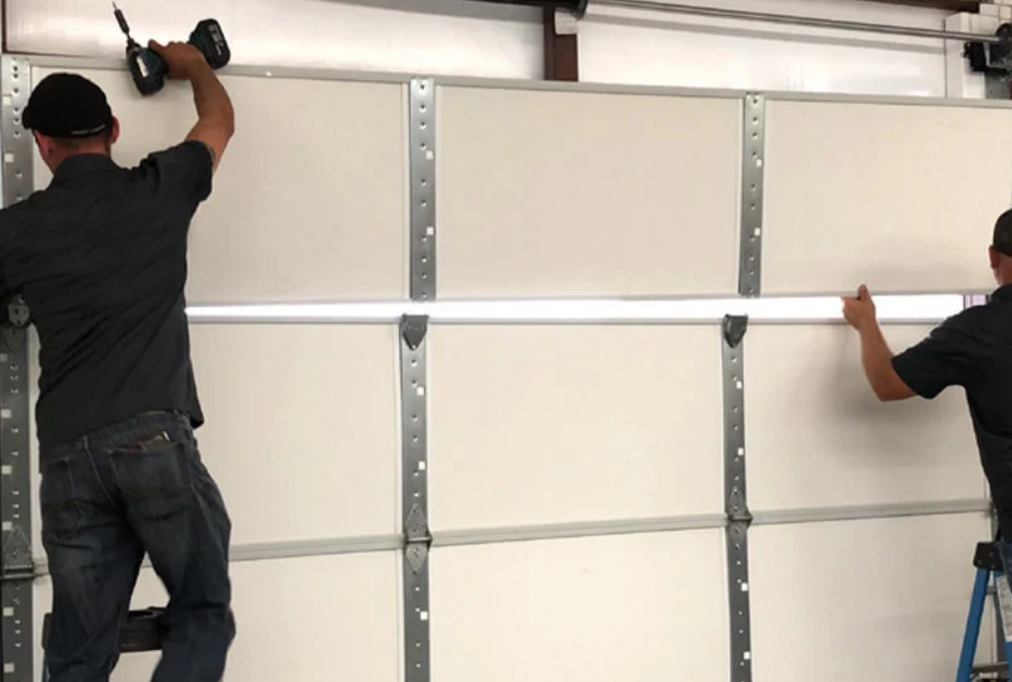 Technicians performing a garage door installation in Sun City Center, Florida, featuring a modern steel garage door.