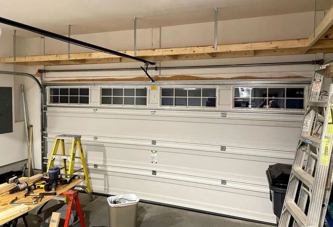 Technician performing a professional garage door installation in Sun City Center, Florida, showcasing modern tools and a newly installed sturdy garage door.