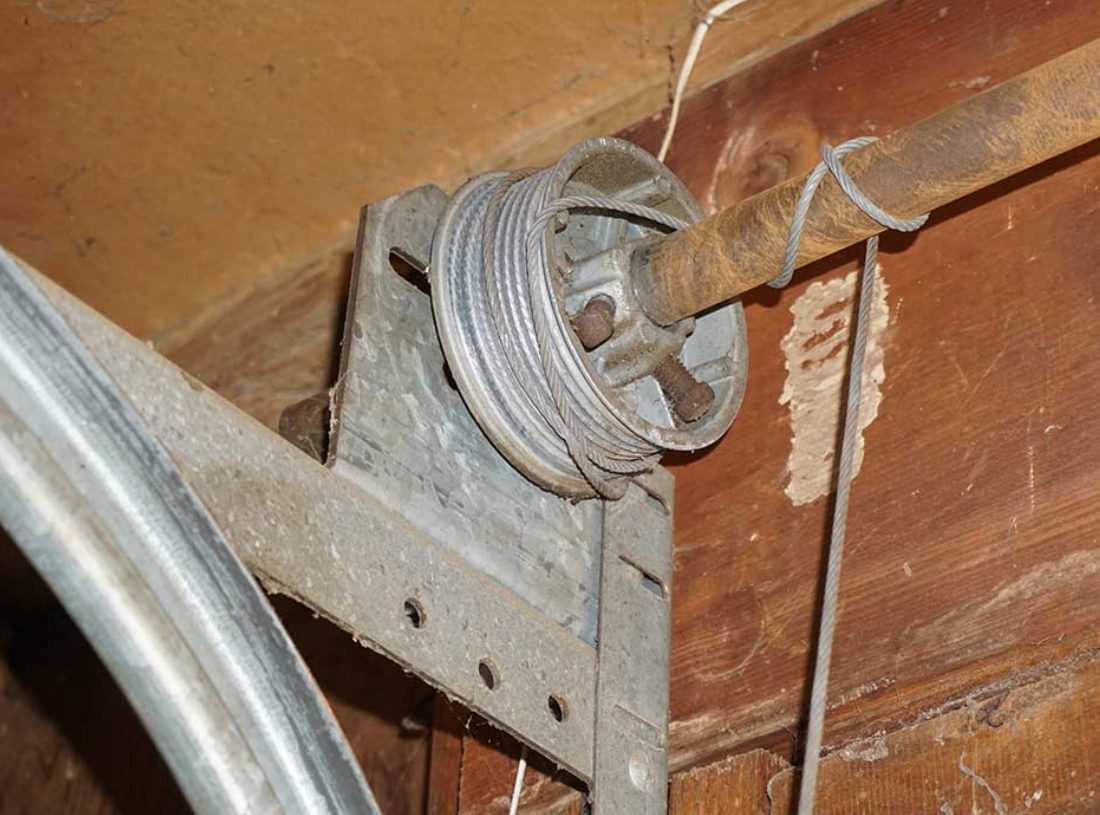 Close-up of a technician repairing a garage door cable on a residential property in Sun City Center, Florida, showcasing professional garage door cable repair services.