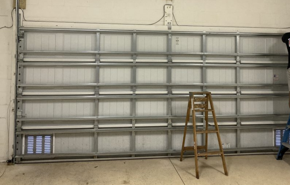 Technician performing a garage door replacement in Sun City Center, Florida, showcasing newly installed modern garage doors