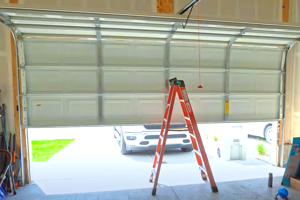 Professional technician repairing a garage door spring, demonstrating the importance of expert garage door repairs for safe and reliable operation."