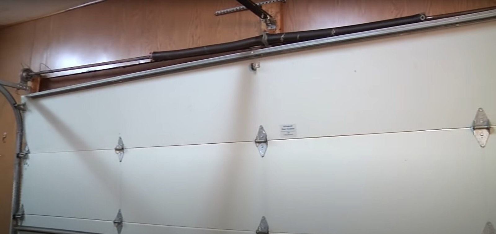 professional technician repairing a garage door spring for a home in Sun City Florida.